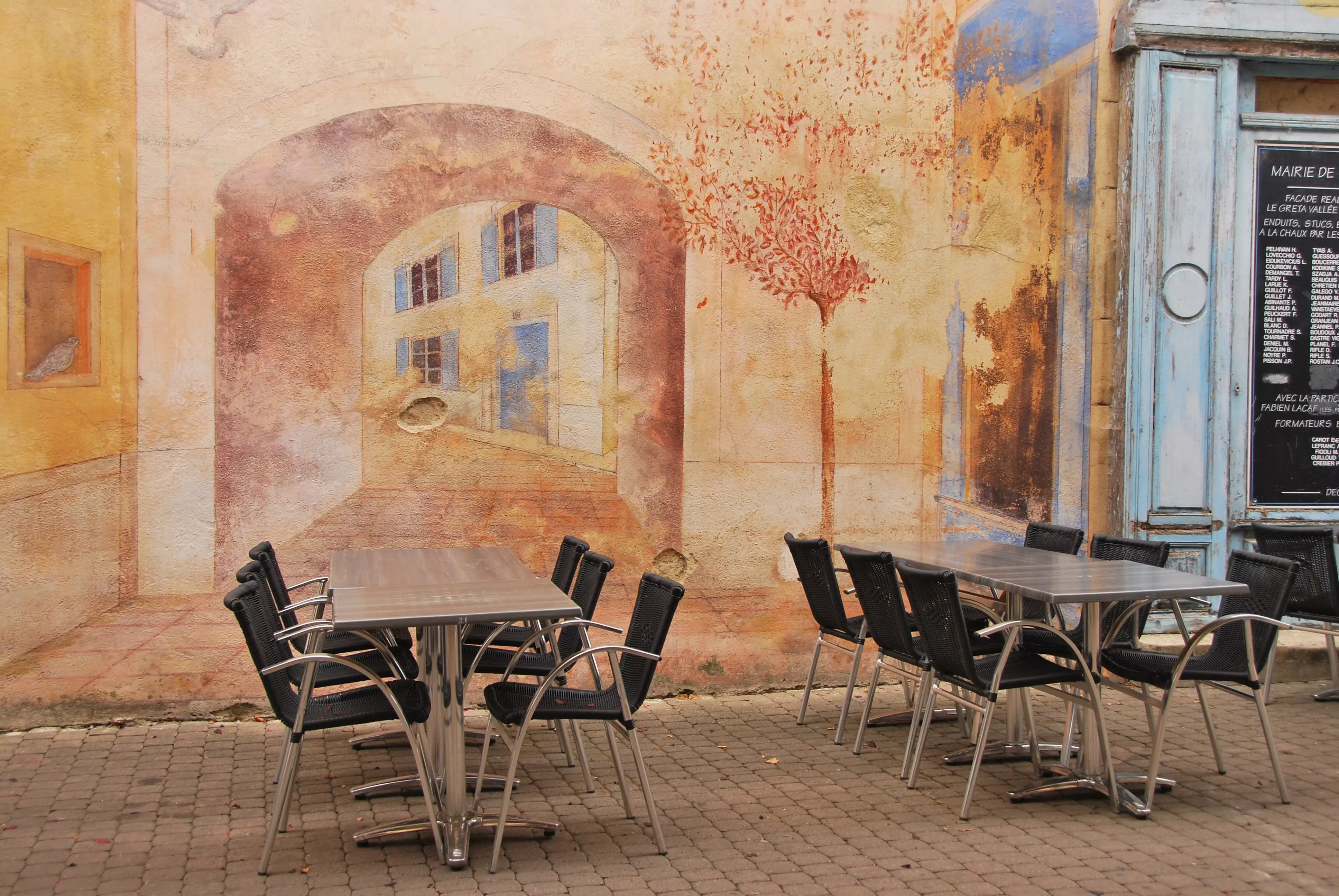 Restaurant wall art installation with tables and chairs